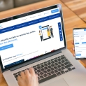 ordinateur portable avec la page d'accueil du site internet de la Cavimac et une main tenant un smartphone