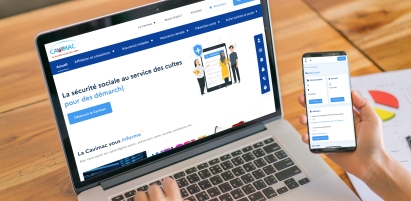 Site internet et espace personnel de la Cavimac ordinateur portable avec la page d'accueil du site internet de la Cavimac et une main tenant un smartphone